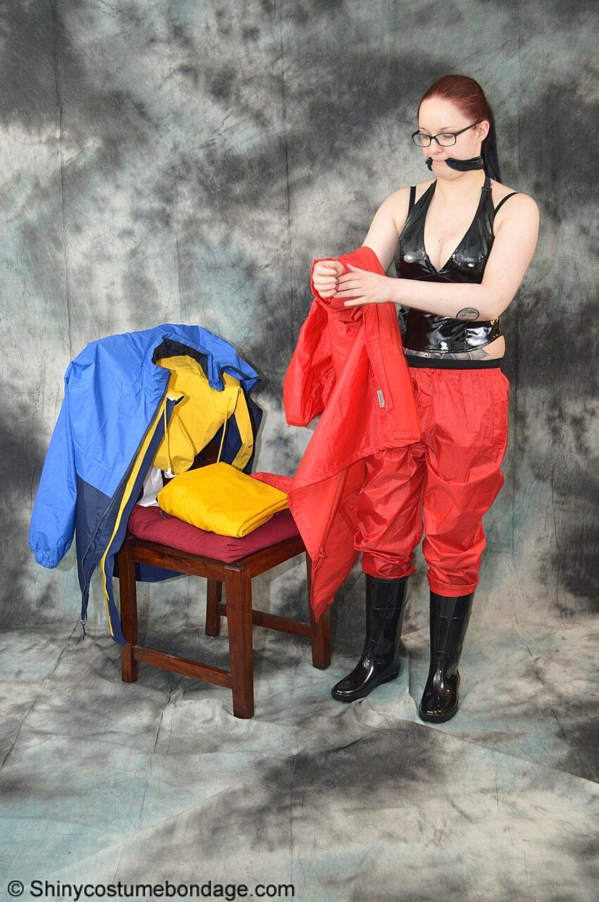 Pale redhead Lady Nadja dons a cleave gag while wearing rain suits